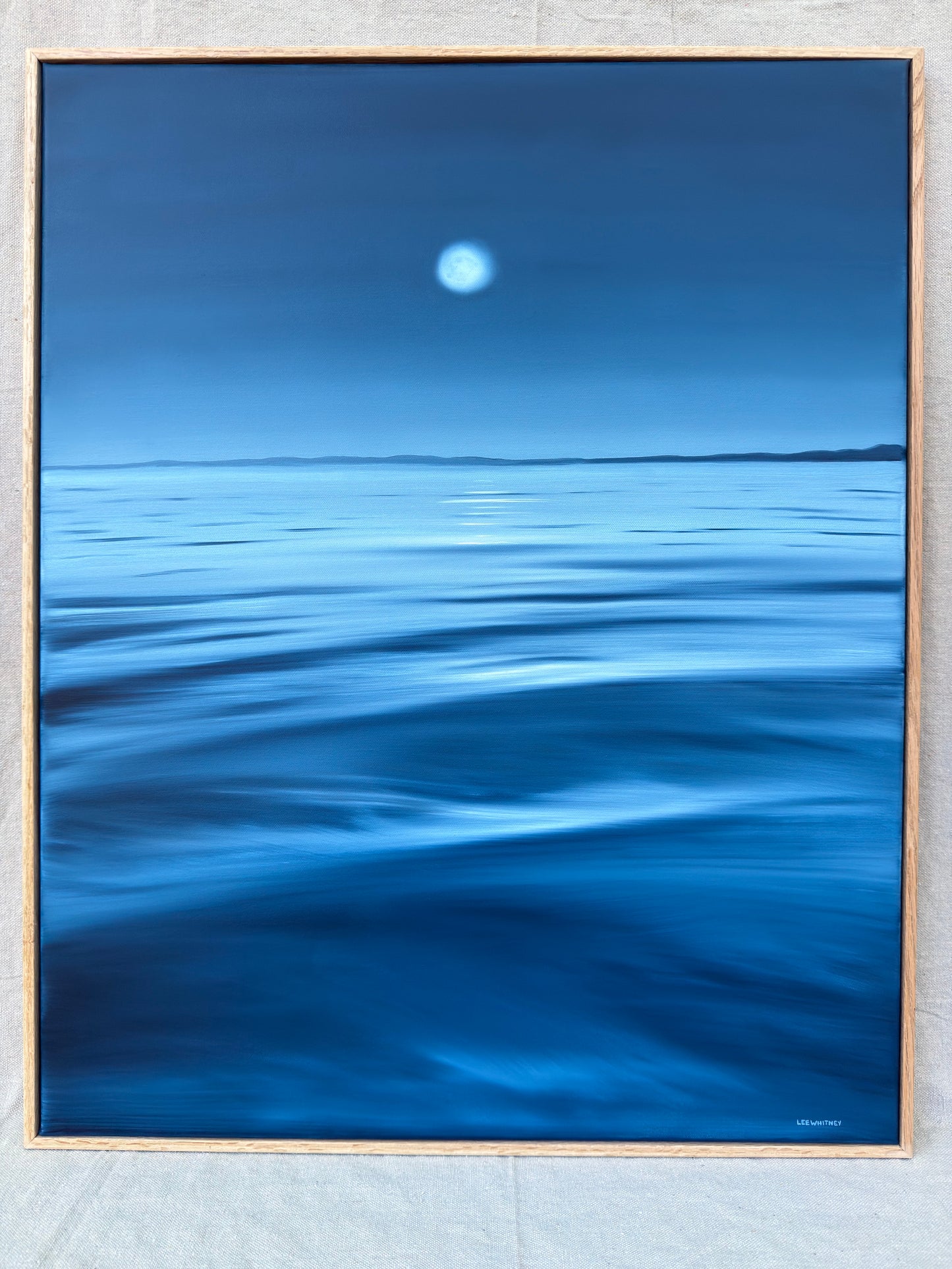 Blue waterscape painting with oak frame