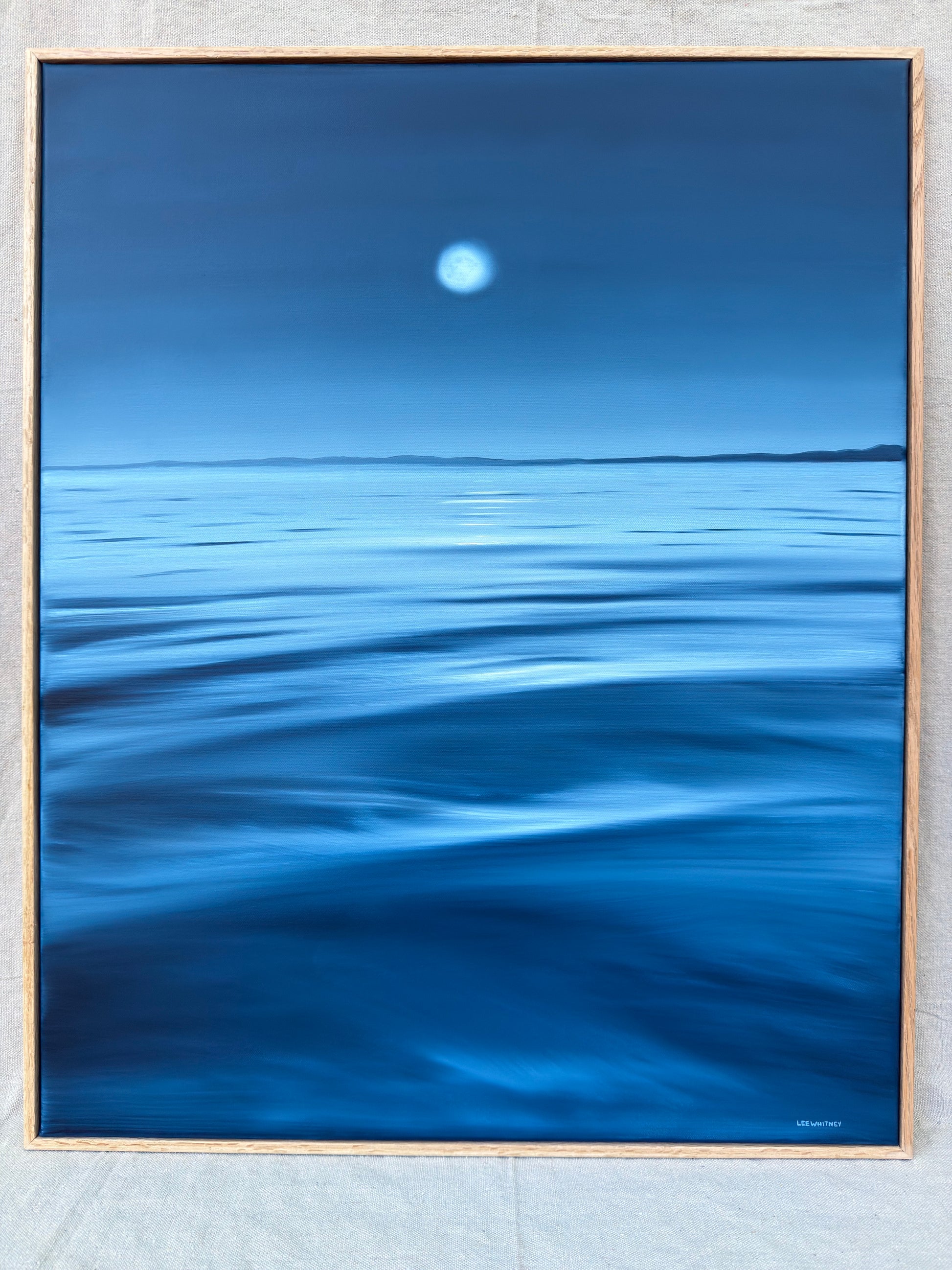 Blue waterscape painting with oak frame