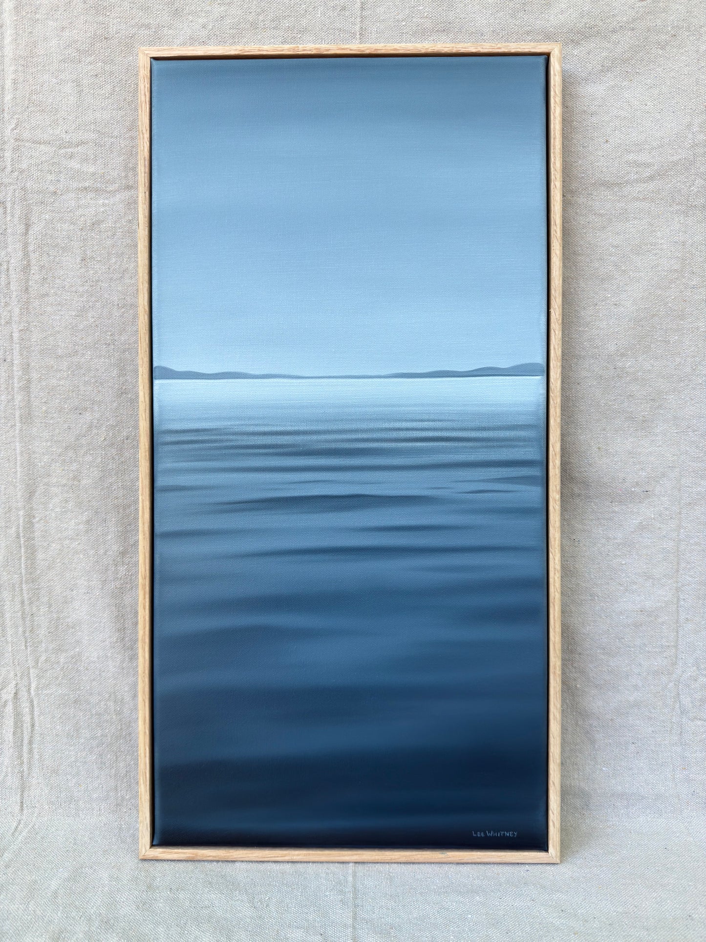Deep blue vertical waterscape painting with oak frame