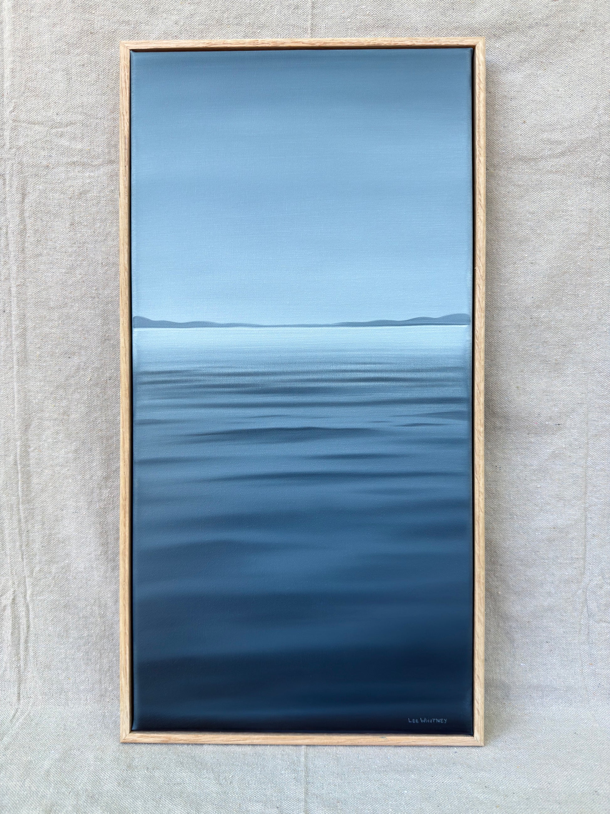 Deep blue vertical waterscape painting with oak frame