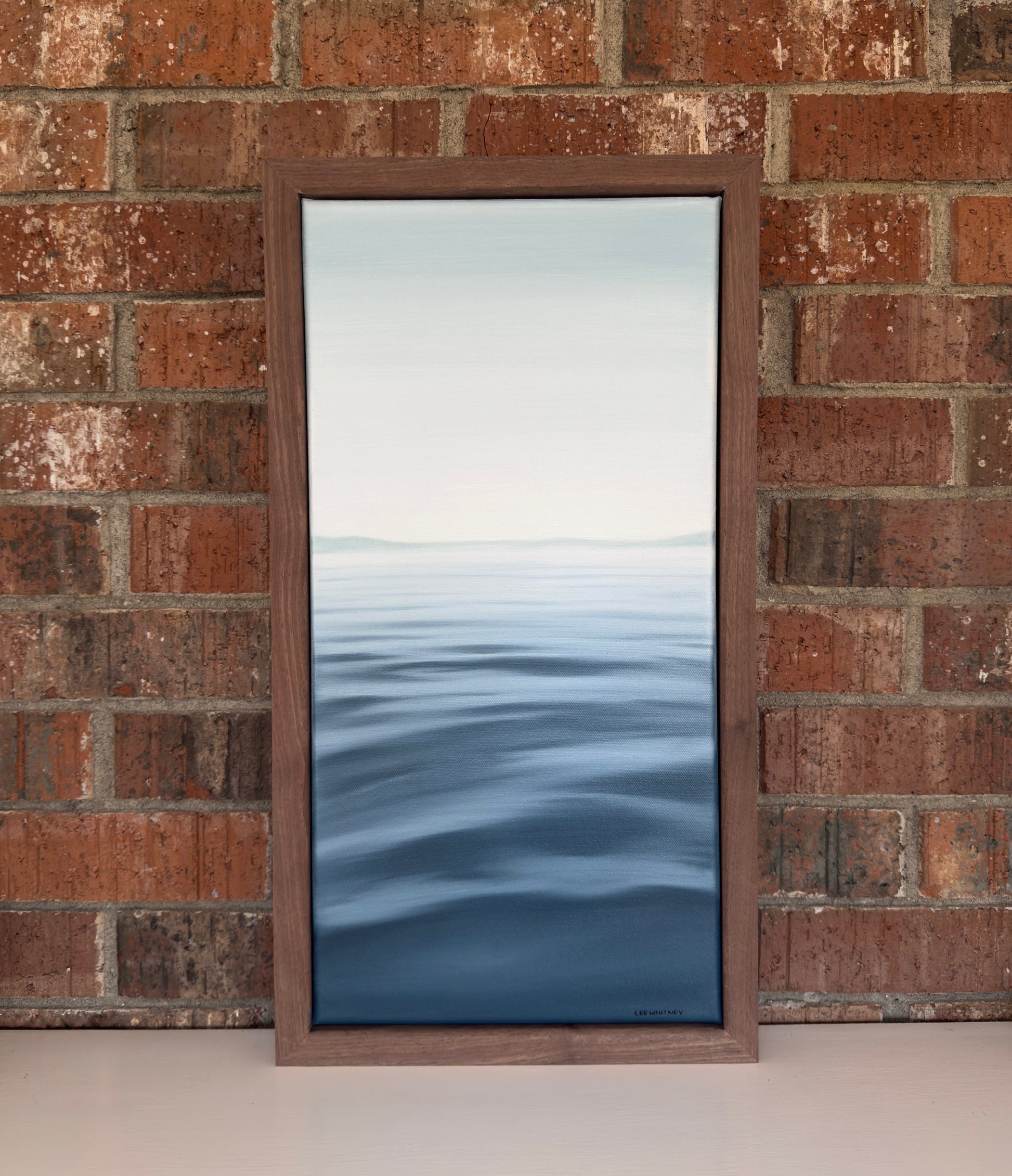 Framed artwork of water on a brick wall